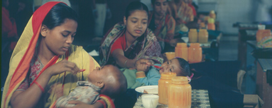 A group of women feeding infants.